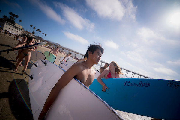 Group of Students Carrying Surfboards at the Beach