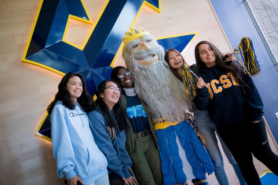 Five Students Huddled with King Triton Mascot