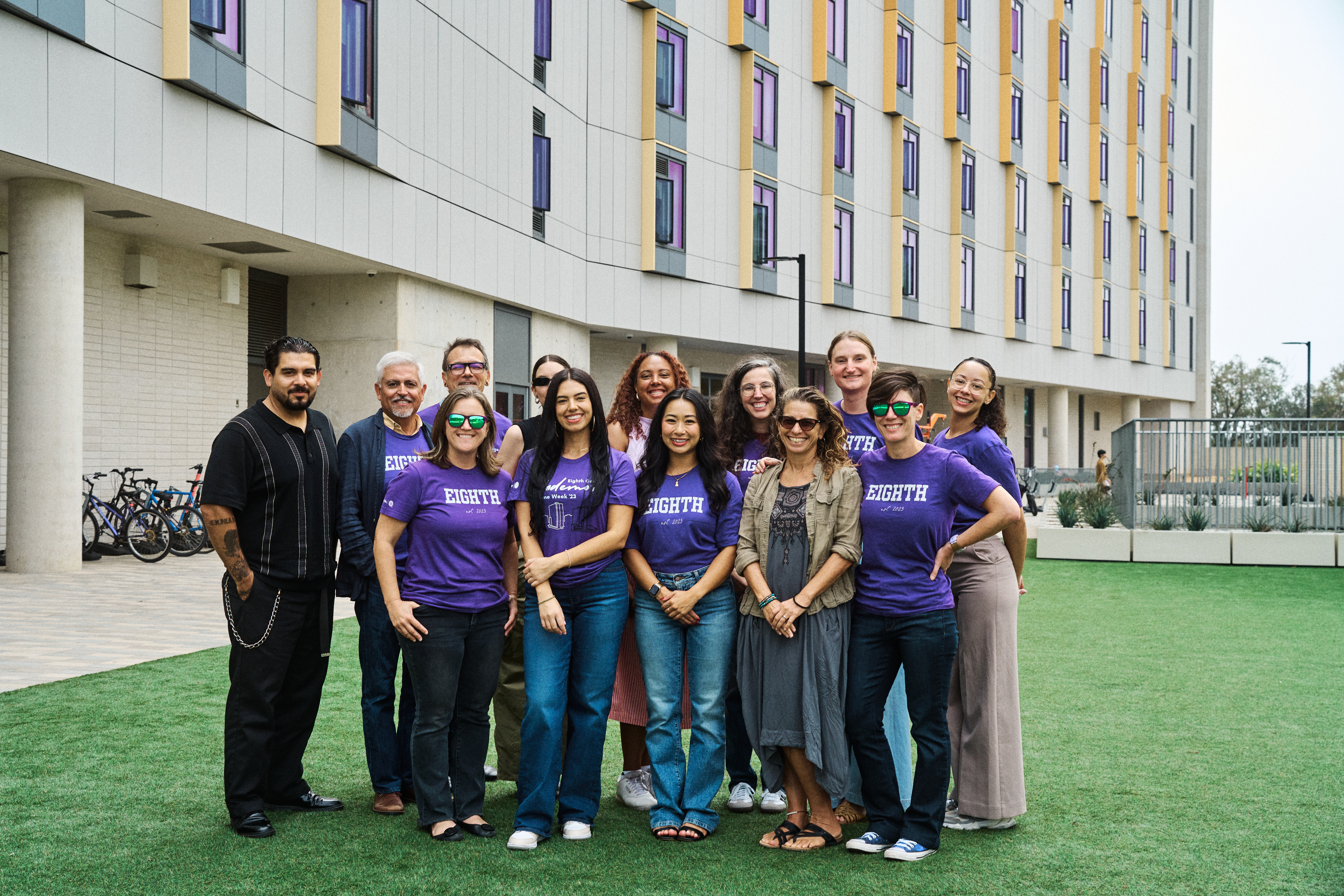 Smiling CCE faculty and staff standing in front of Azad, one of Eighth College's buildings